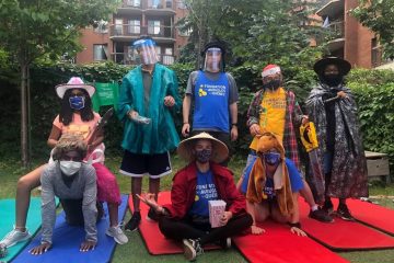 Quatre accompagnateurs et quatre participants posent pour la caméra dans des habits loufoques.