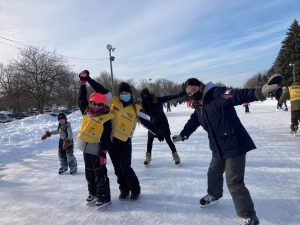 Une participante tient la main d’une accompagnatrice alors que deux autres accompagnatrices posent avec elles pour la caméra.