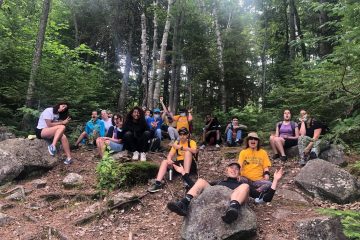 Une photo du groupe dispersé dans la forêt lors du séjour au camp Richelieu.