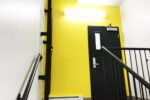 Description de l'image: Photo de l'entrée au niveau rez-de-jardin démontrant la couleur jaune représentant le 1er étage
