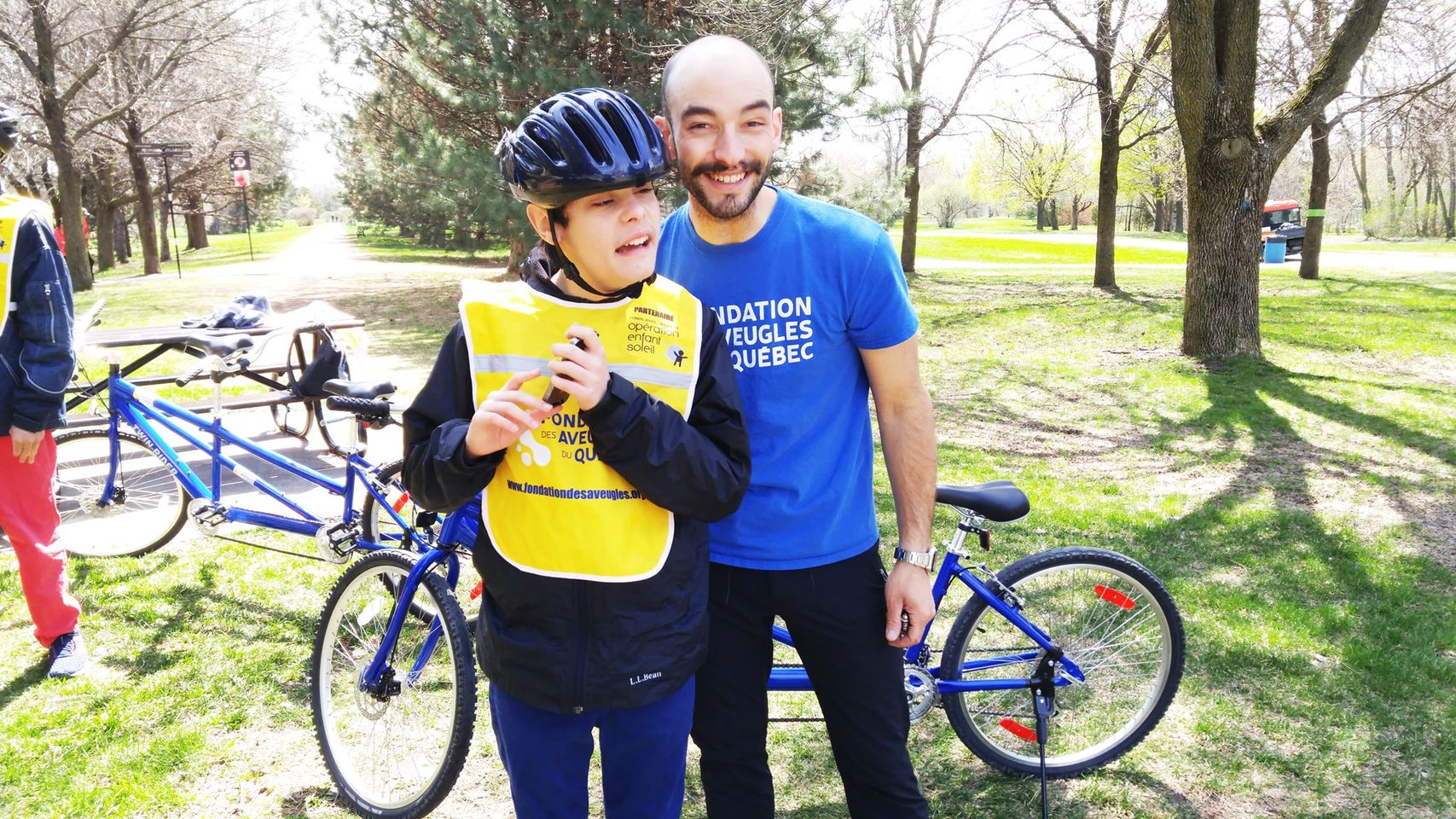Description de l'image: Maxime pose avec un participant durant une activité vélo-tandem