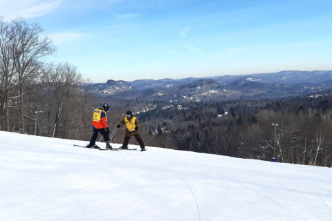 Description de l'image: Un participant et un moniteur skient au mont Chantecler