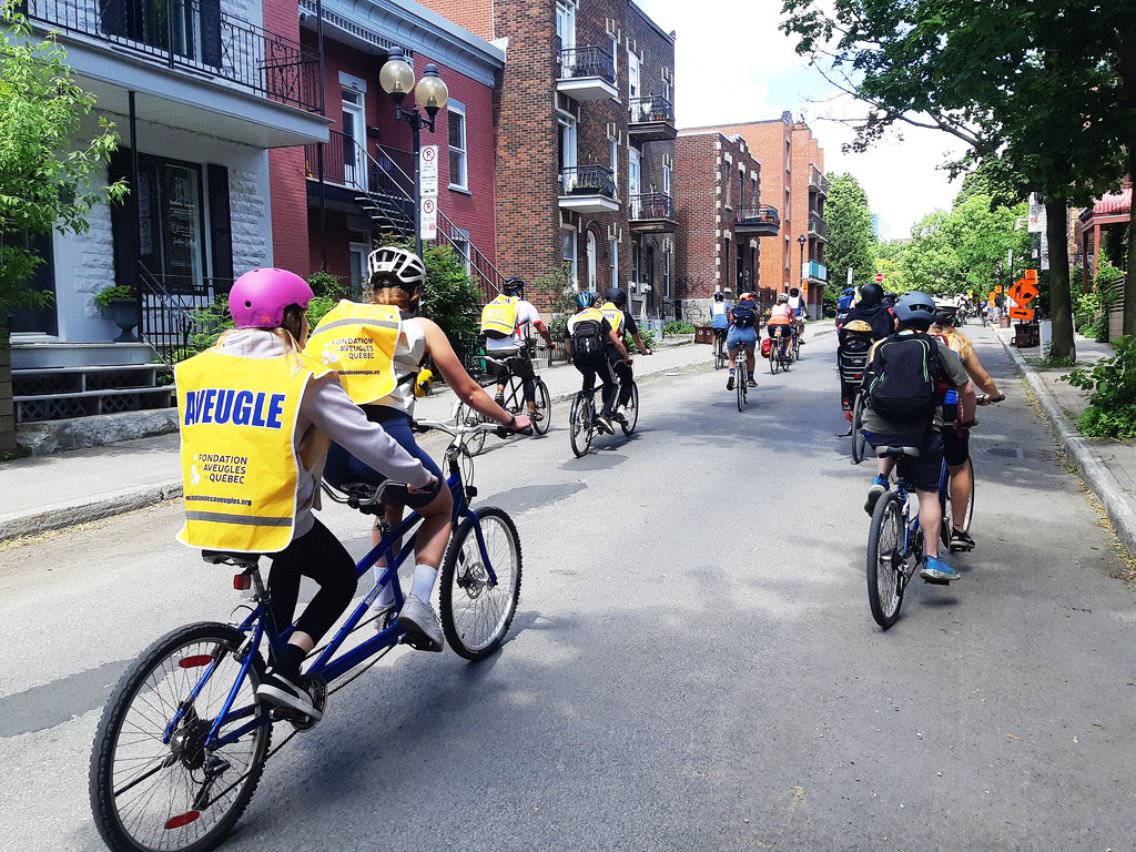Description de l'image: Photo prise sur le vif de participants du tour de l'ile en déplacement dans les rues de Montréal.
