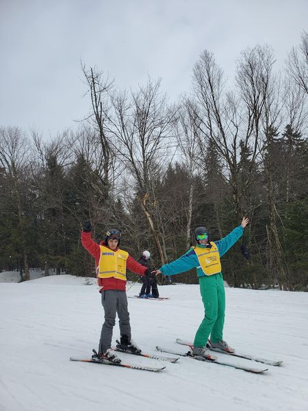 Description de l'image: un guide et un participant en ski se tenant par la main