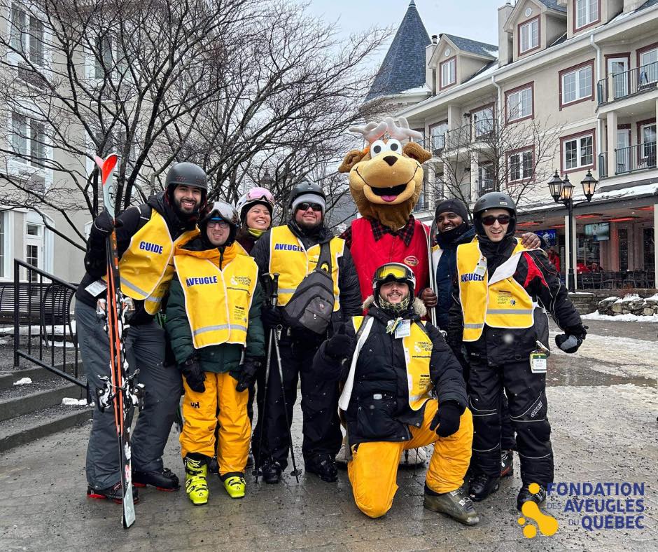 Photo de groupe dans le village du Mont-Tremblant avec la mascotte de la montagne.